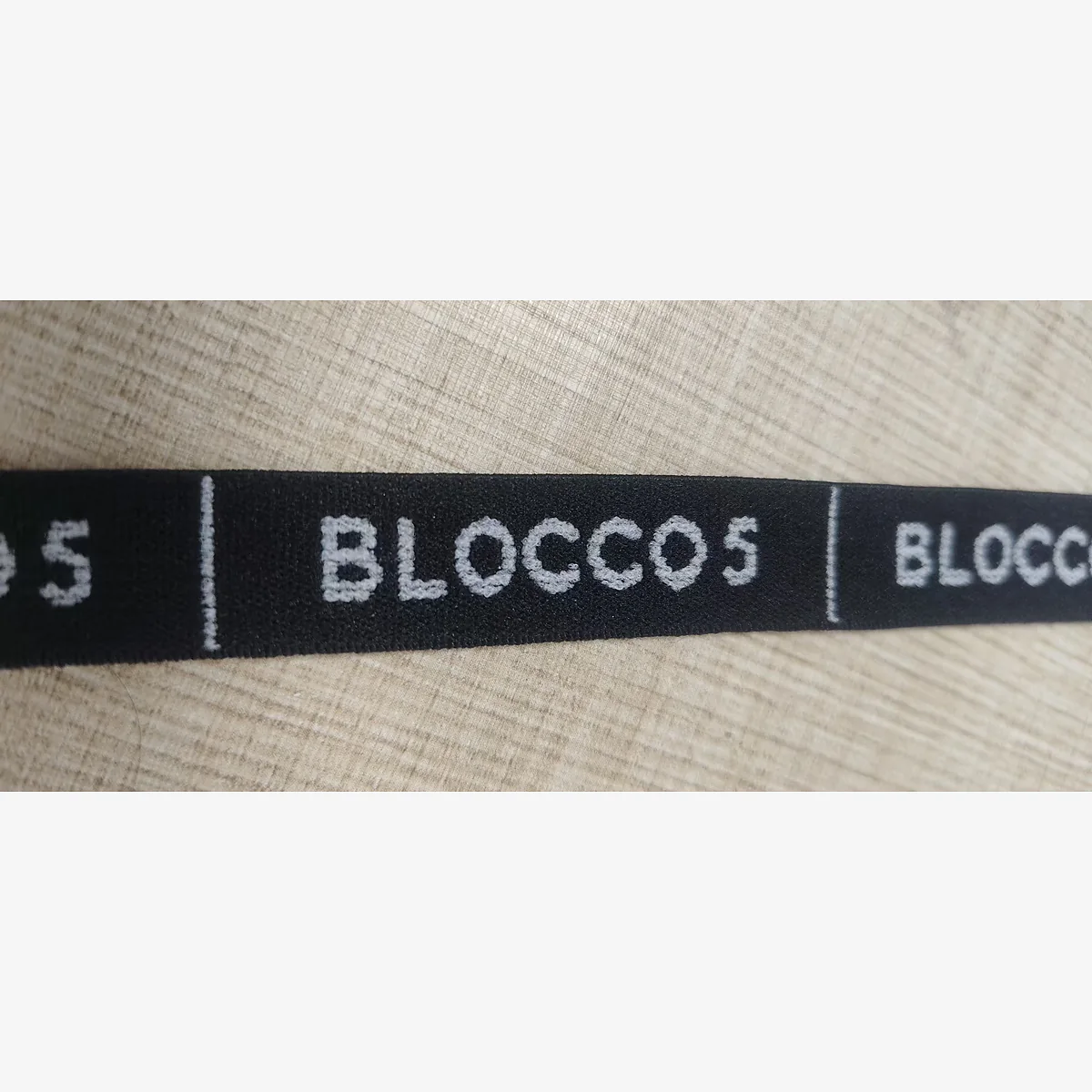 Close up of custom logo jacquard elastic band sample in black nylon spandex