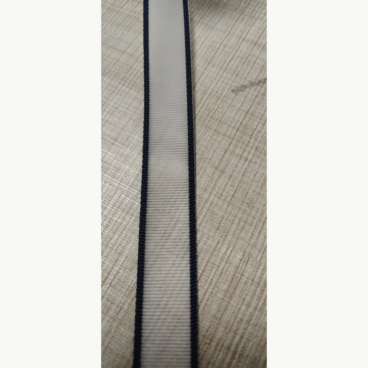 Texture detail of stiff nylon webbing with black edges and light center