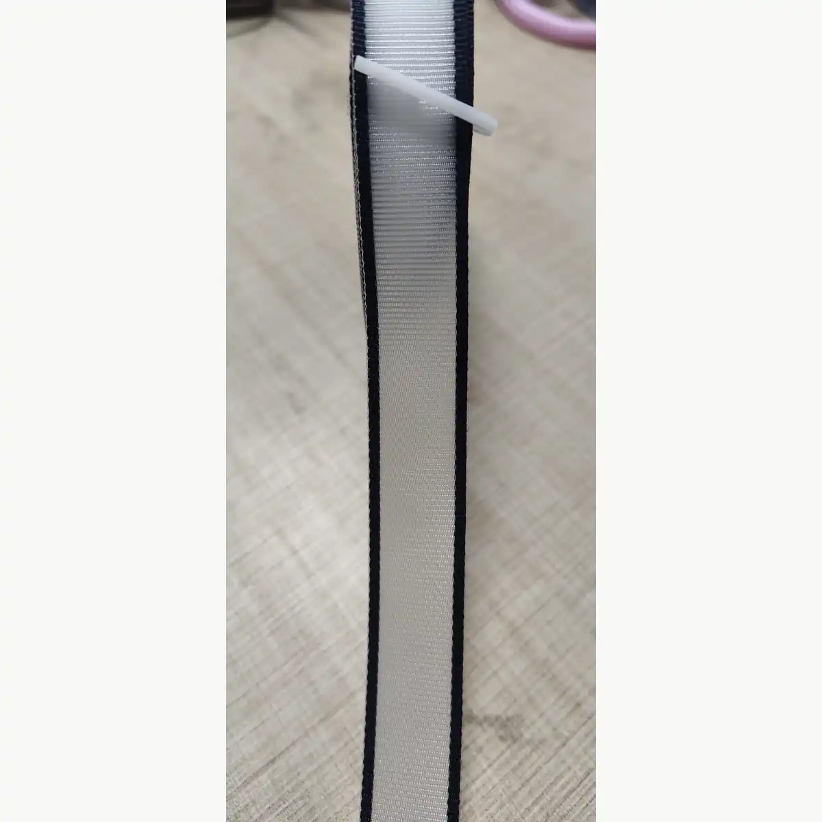Close up of two-tone nylon webbing reinforced with monofilament insert