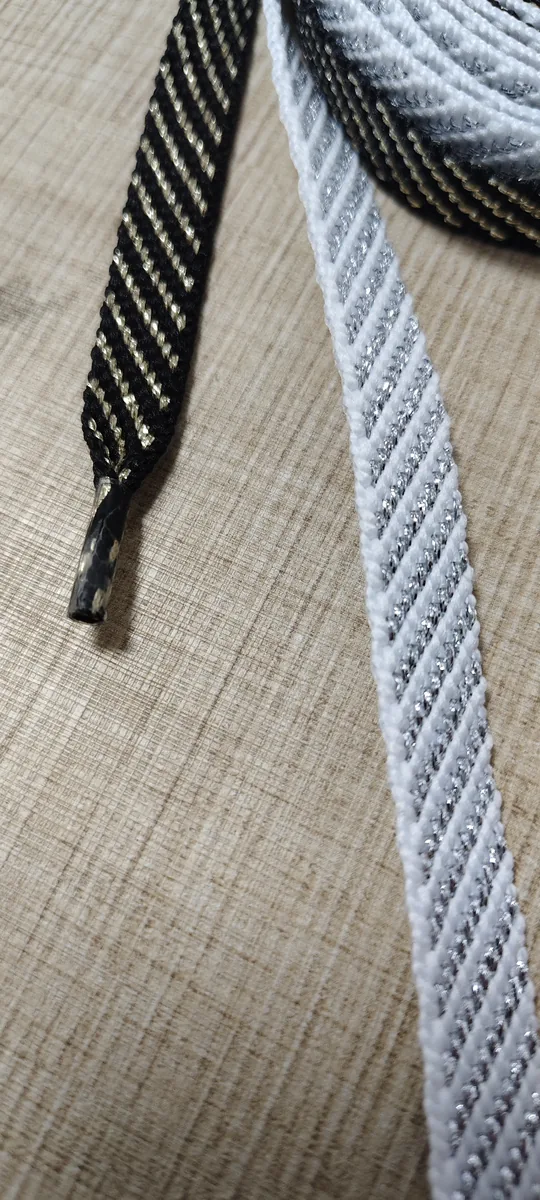 Close-up of gold and silver metallic yarn woven into 8mm polyester flat shoelaces