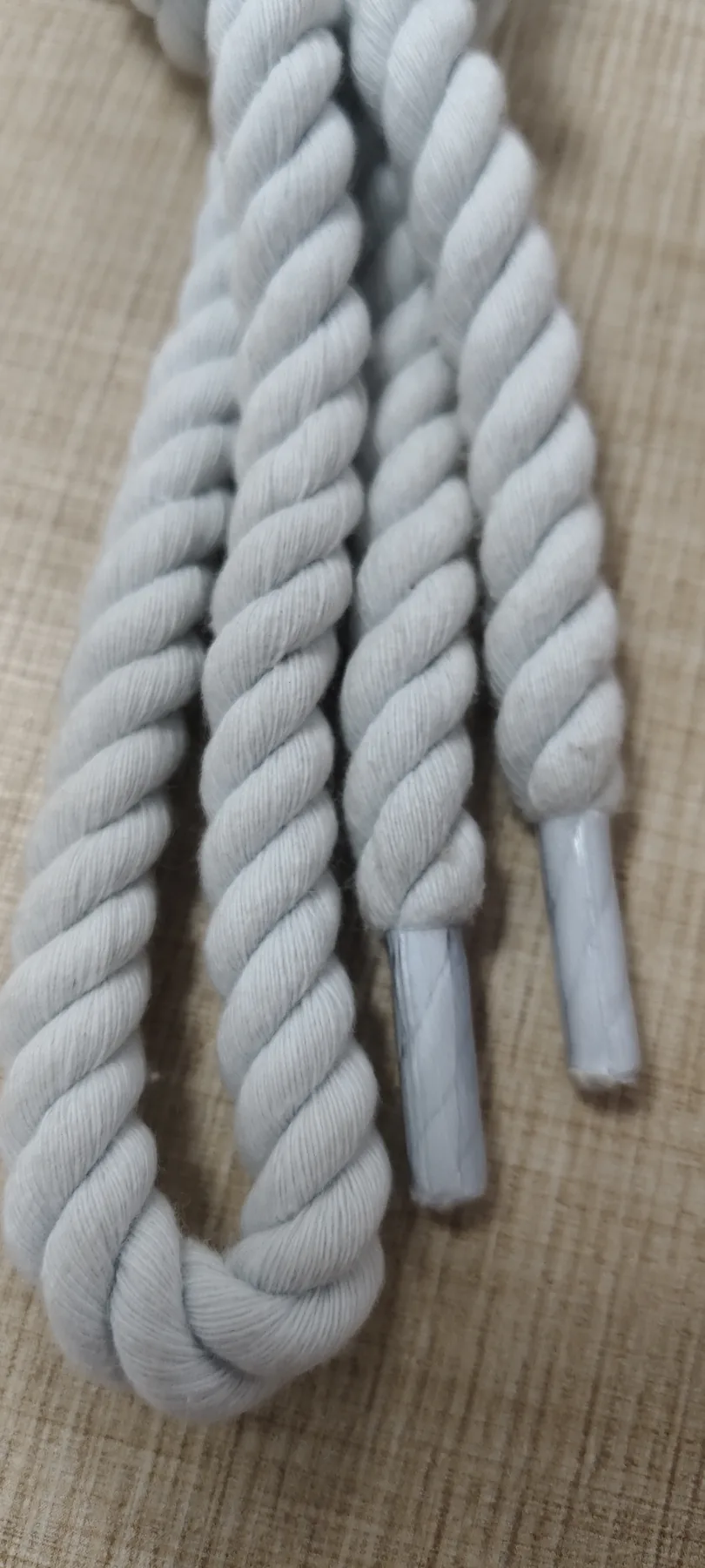 Close-up of white polyester twisted rope shoelaces and aglets