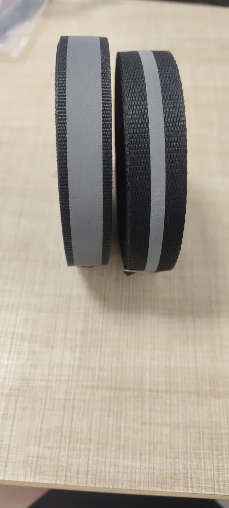 Two rolls of black 15mm polyester webbing with gray reflective strips