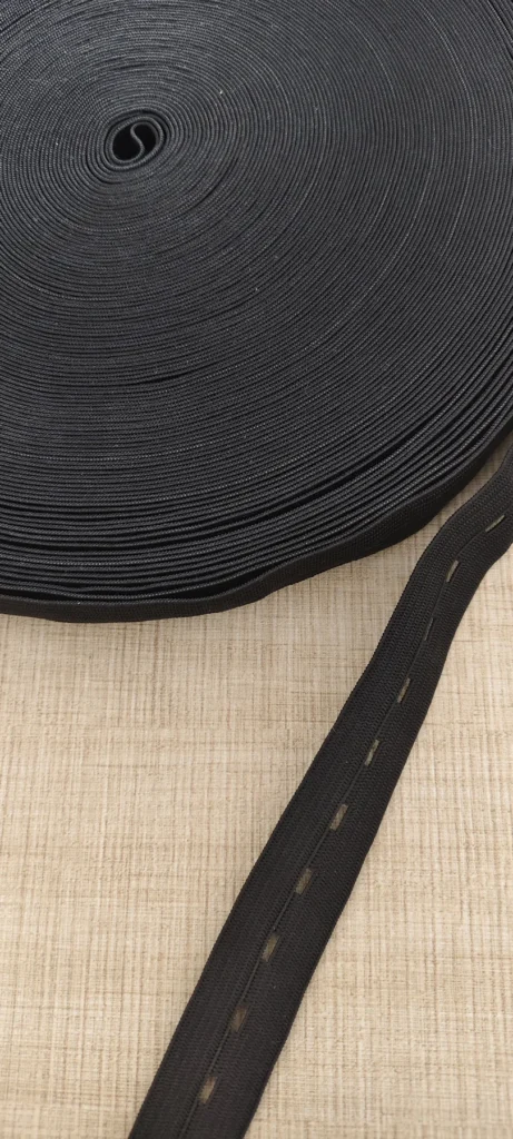 Black 20mm polyester buttonhole elastic band in a large roll