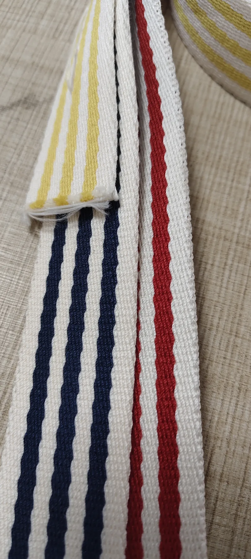 Close view of 30mm striped polyester webbing in navy red and yellow