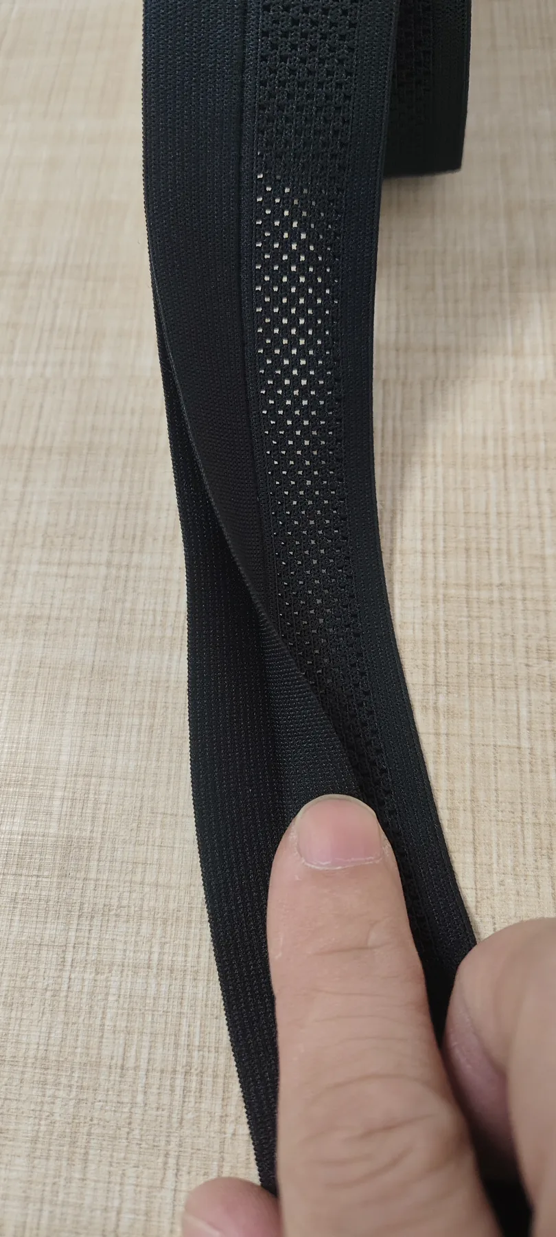 Hand-opened view of the mesh center in black 35mm waistband elastic